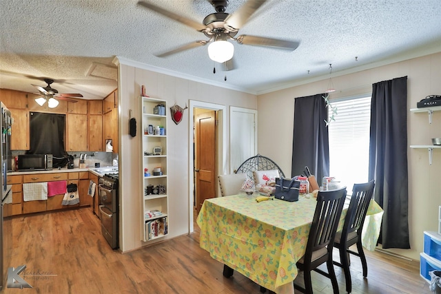 dining room featuring a textured ceiling, wood-type flooring, and crown molding