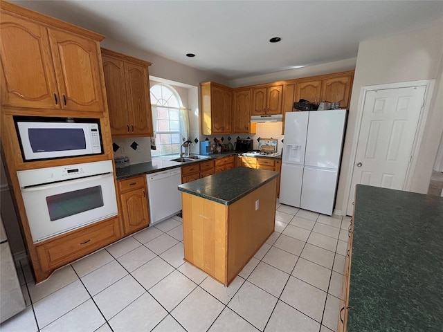 kitchen with sink, white appliances, backsplash, a kitchen island, and light tile patterned flooring