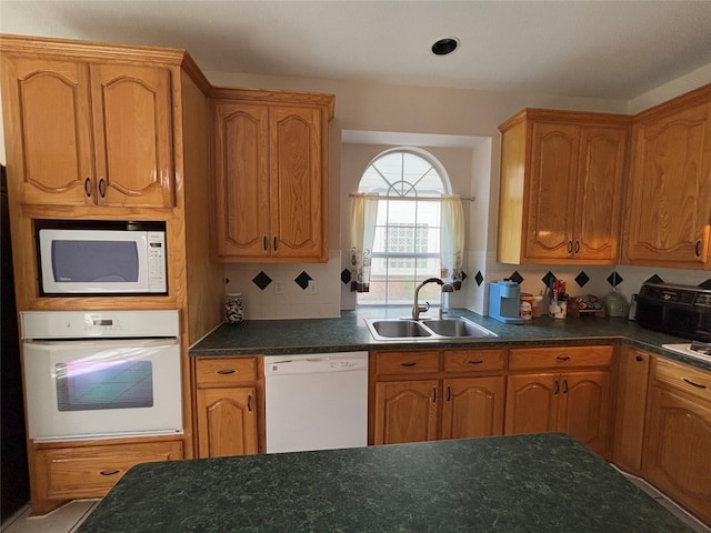 kitchen with tasteful backsplash, sink, and white appliances