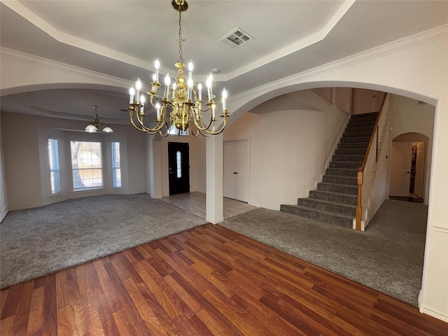 interior space with wood-type flooring, ornamental molding, and a raised ceiling