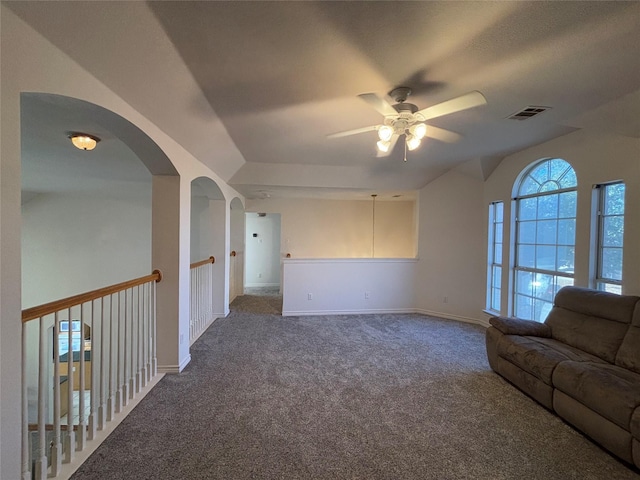 unfurnished living room with ceiling fan and dark carpet