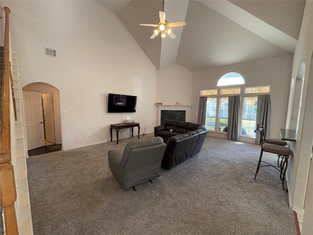 carpeted living room with ceiling fan, a premium fireplace, and high vaulted ceiling