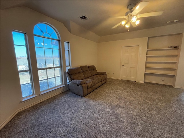 sitting room featuring ceiling fan, lofted ceiling, dark carpet, and built in shelves