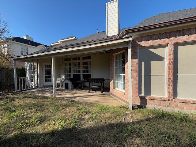 back of house with a lawn and a patio area