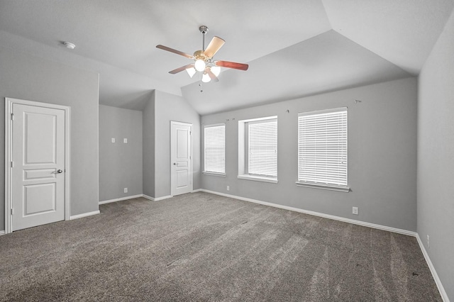 carpeted empty room with vaulted ceiling and ceiling fan