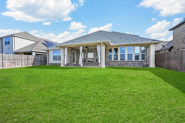 rear view of property with a patio area, ceiling fan, and a yard