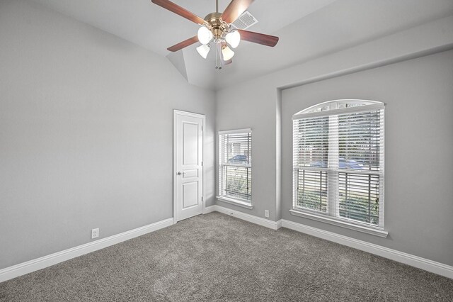 empty room featuring ceiling fan, a healthy amount of sunlight, lofted ceiling, and carpet floors