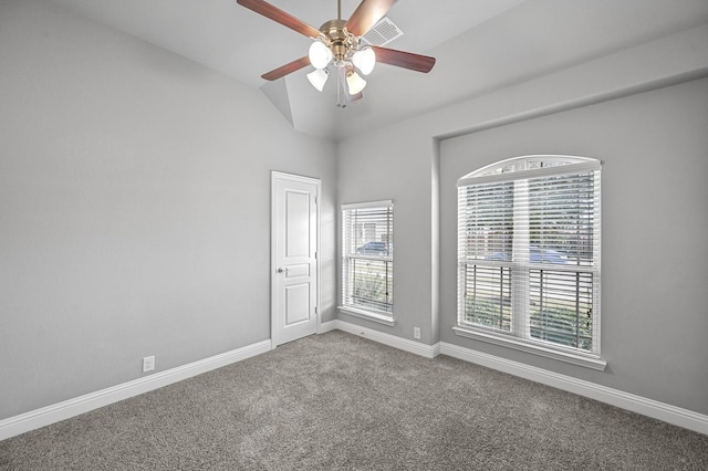 empty room with ceiling fan, carpet flooring, and vaulted ceiling