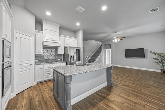 kitchen with a center island with sink, dark hardwood / wood-style flooring, white cabinets, and appliances with stainless steel finishes