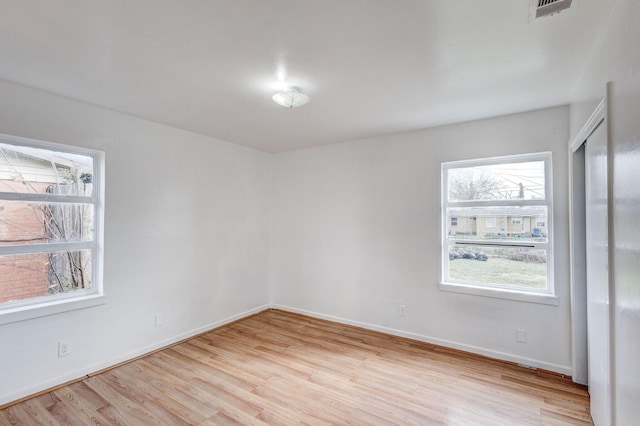 unfurnished room featuring plenty of natural light and light hardwood / wood-style floors