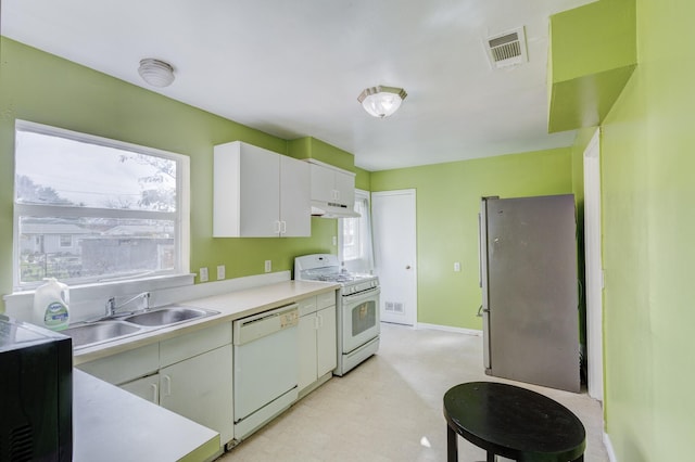 kitchen with sink, white cabinets, and white appliances