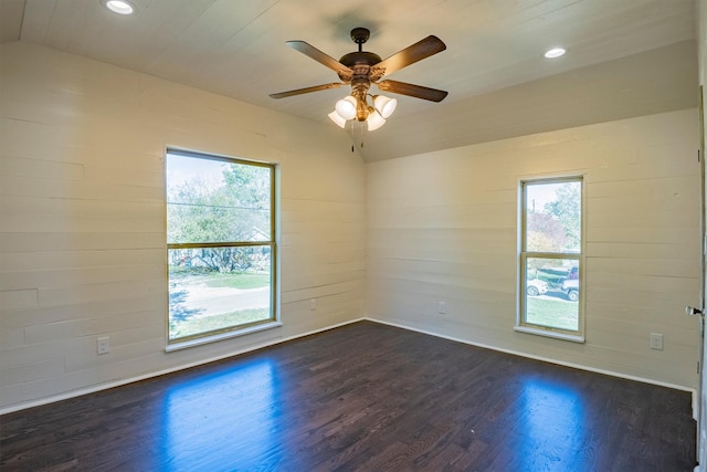 empty room with ceiling fan, dark wood-type flooring, a healthy amount of sunlight, and lofted ceiling