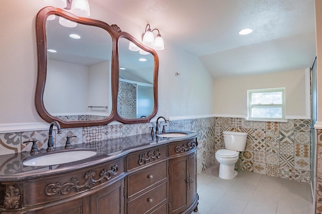 bathroom featuring vanity, tile patterned floors, vaulted ceiling, toilet, and tile walls