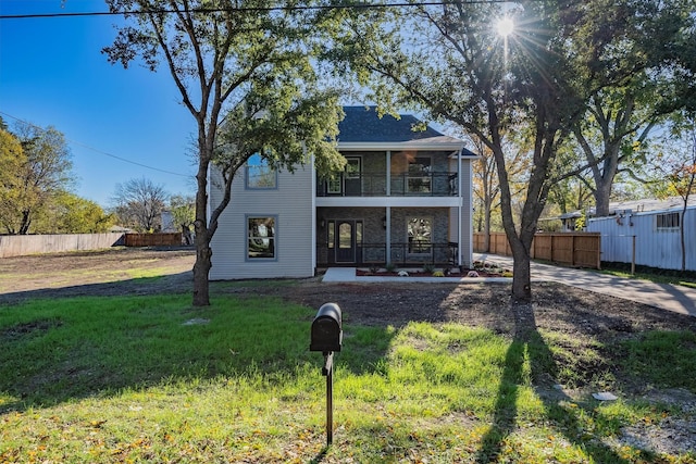 view of front of home with a balcony and a front lawn