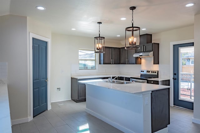 kitchen featuring backsplash, stainless steel range with electric stovetop, dark brown cabinets, sink, and an island with sink