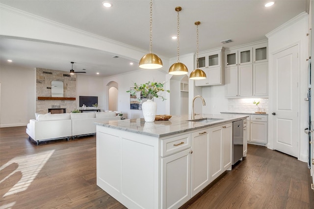 kitchen featuring light stone countertops, a kitchen island with sink, sink, white cabinets, and dark hardwood / wood-style floors