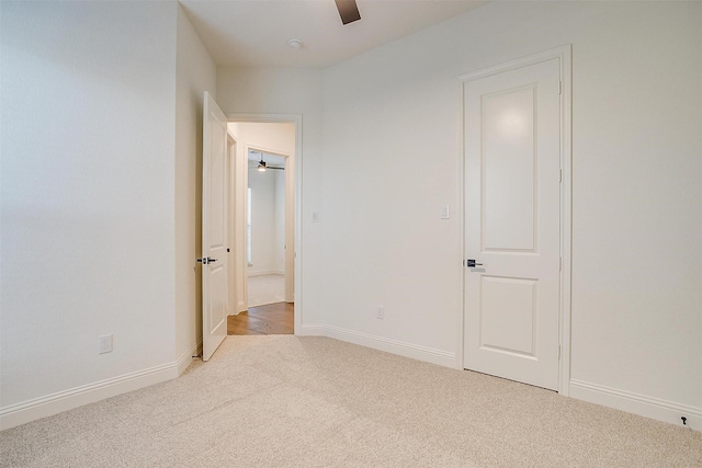 unfurnished bedroom with ceiling fan and light colored carpet