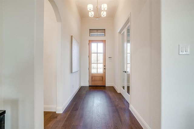 entryway with dark hardwood / wood-style flooring and a chandelier