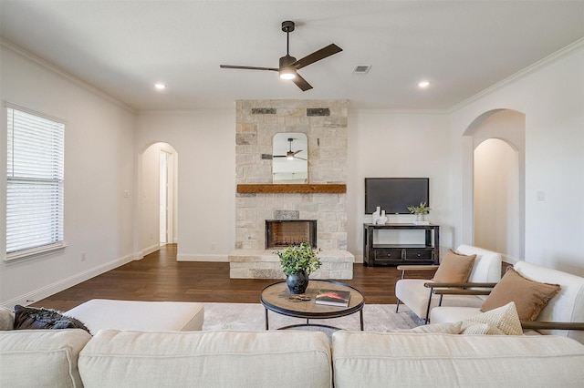 living room with a fireplace, crown molding, hardwood / wood-style floors, and ceiling fan