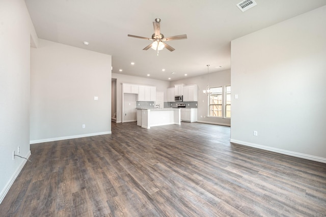 unfurnished living room featuring ceiling fan, sink, and dark hardwood / wood-style floors