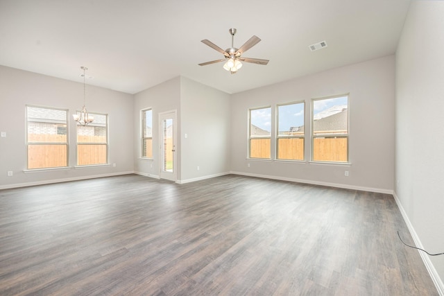 empty room with ceiling fan with notable chandelier and dark hardwood / wood-style floors