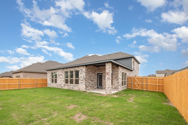 rear view of property featuring a lawn and a patio