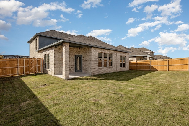 rear view of property featuring a lawn and a patio