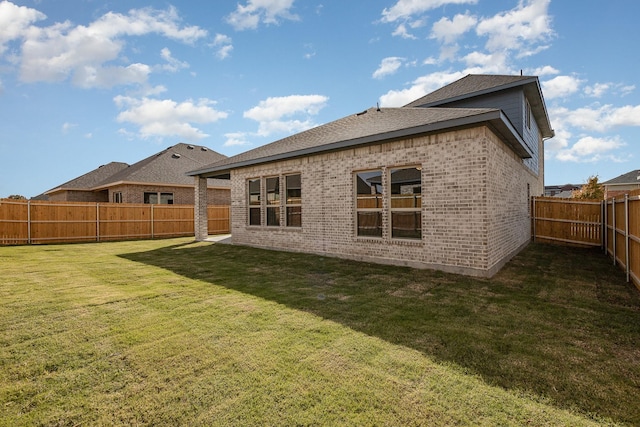 rear view of house featuring a yard