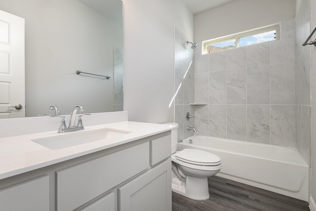 full bathroom featuring hardwood / wood-style flooring, tiled shower / bath combo, toilet, and vanity