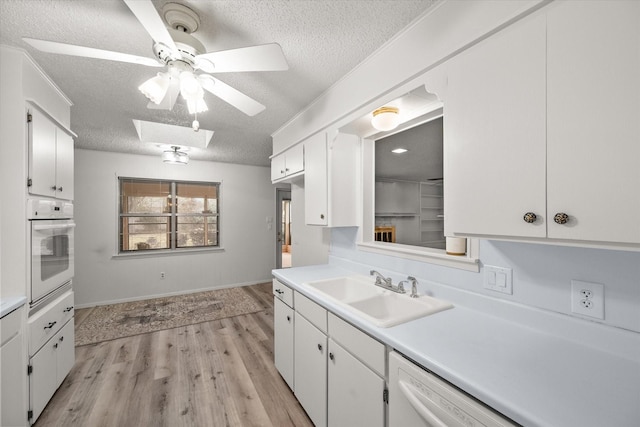 kitchen with white cabinetry, sink, and white appliances