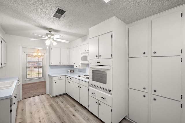 kitchen featuring white cabinetry, white appliances, ceiling fan with notable chandelier, and light wood-type flooring