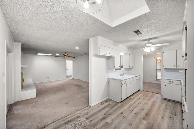 kitchen featuring light wood-type flooring, ceiling fan, sink, and white cabinets