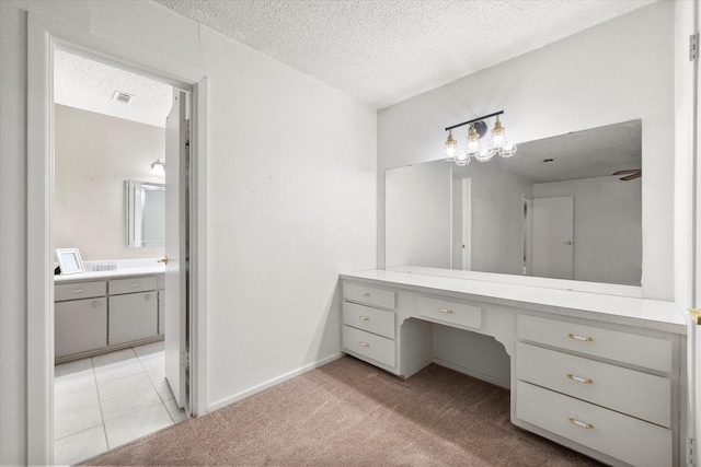 bathroom with vanity, tile patterned flooring, and a textured ceiling