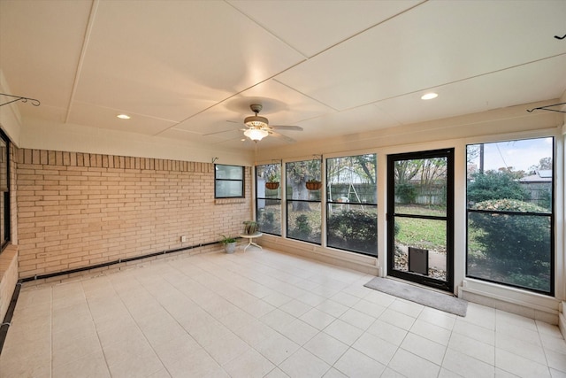 unfurnished sunroom with ceiling fan