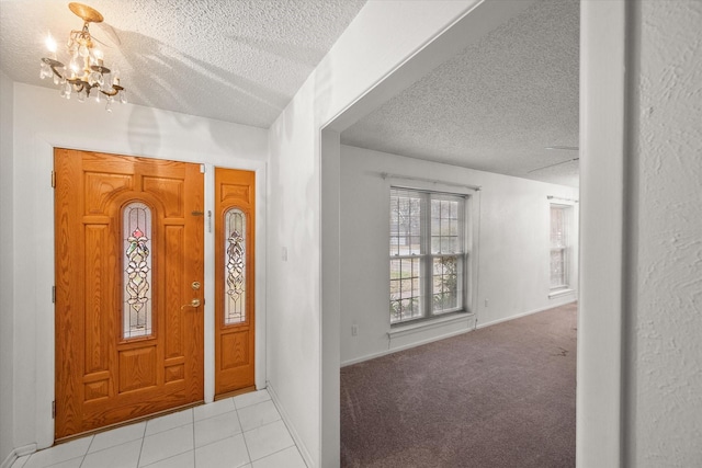 carpeted entryway with a chandelier and a textured ceiling