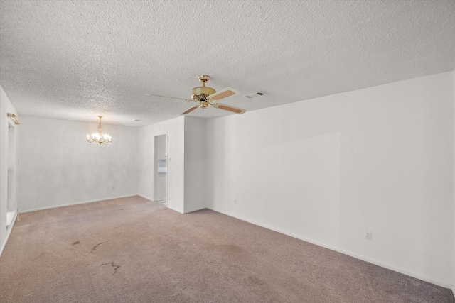 carpeted spare room featuring ceiling fan with notable chandelier and a textured ceiling