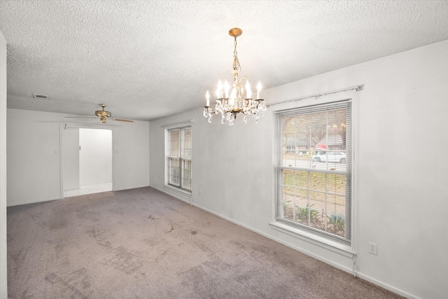 carpeted spare room with ceiling fan with notable chandelier and a textured ceiling