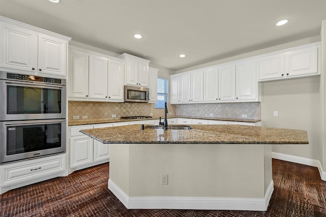 kitchen with stainless steel appliances, white cabinetry, and sink