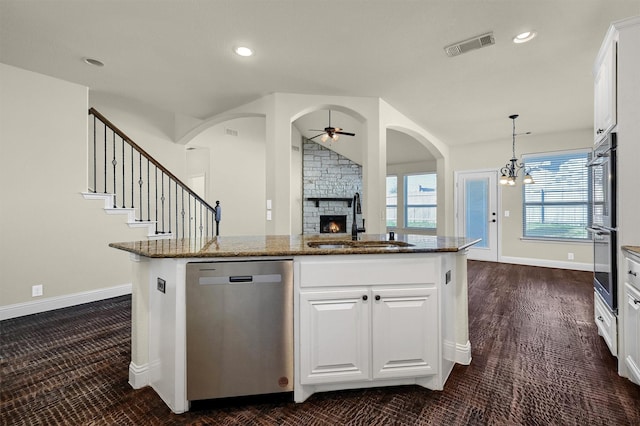 kitchen with white cabinetry, sink, dark stone countertops, a kitchen island with sink, and stainless steel dishwasher