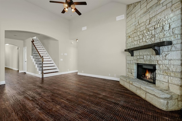 unfurnished living room with ceiling fan, a fireplace, dark hardwood / wood-style flooring, and high vaulted ceiling