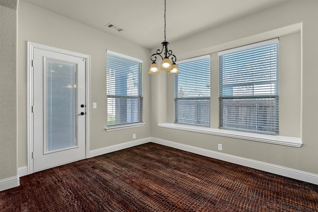 unfurnished dining area featuring a chandelier