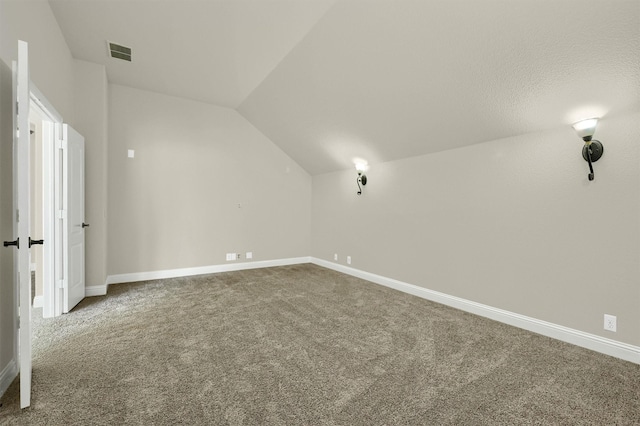 additional living space with vaulted ceiling and carpet