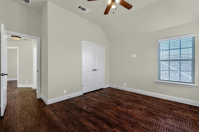 unfurnished bedroom featuring dark wood-type flooring, vaulted ceiling, a closet, and ceiling fan