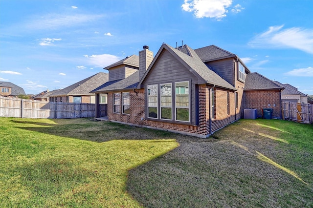 back of property with a lawn and central air condition unit