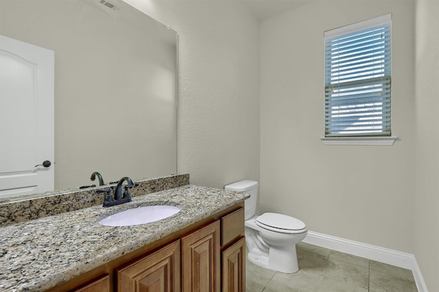 bathroom with vanity, toilet, and tile patterned flooring