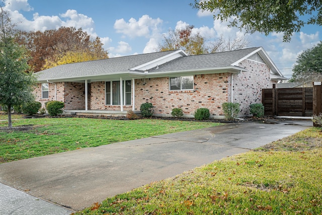 ranch-style house with covered porch and a front yard