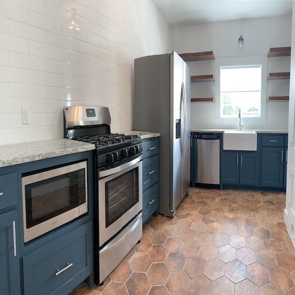 kitchen with tasteful backsplash, sink, blue cabinetry, and appliances with stainless steel finishes