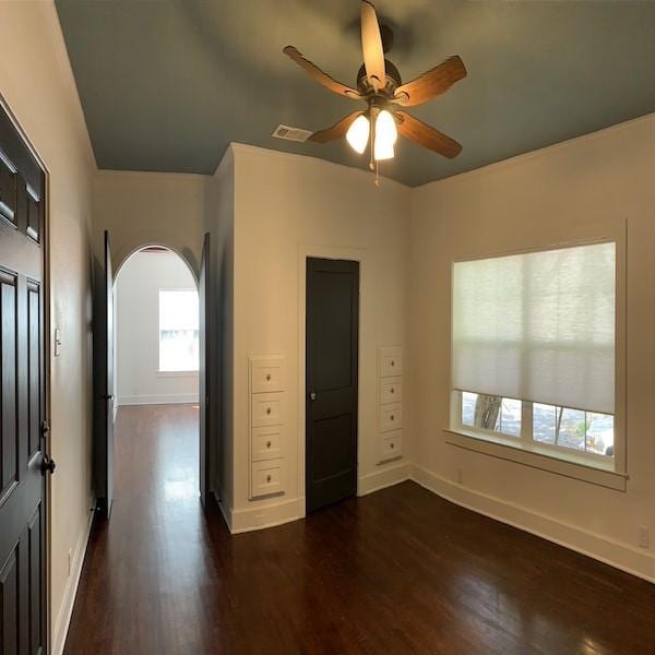 unfurnished bedroom featuring ceiling fan and dark hardwood / wood-style flooring