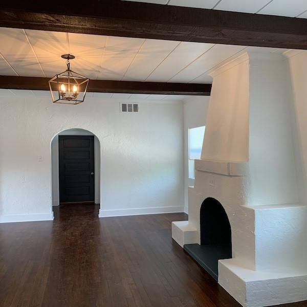 unfurnished living room featuring dark hardwood / wood-style floors, a chandelier, and beam ceiling