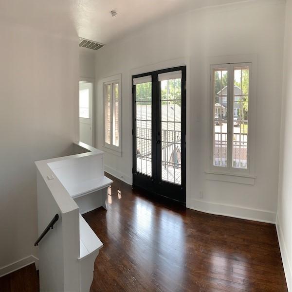 foyer entrance featuring a healthy amount of sunlight, dark wood-type flooring, and french doors